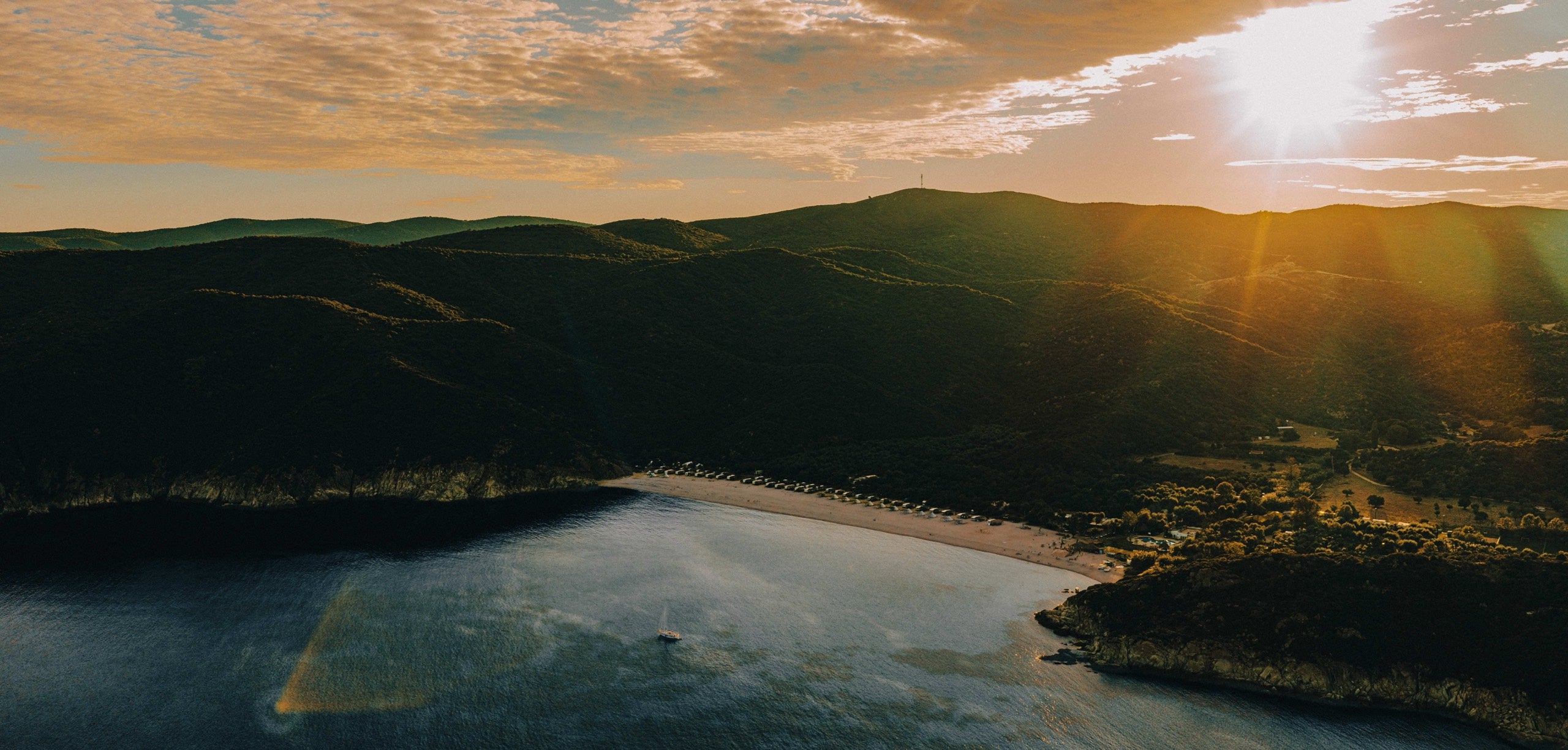 Kalamitsi Bay at first light — the Omana festival site from above